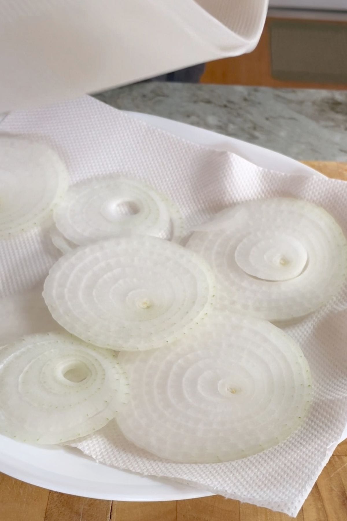 Removing moisture from sliced onions with paper towel.